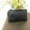 back of black clutch bag with leaves in the background