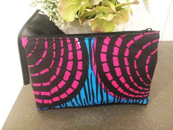 Fabric clutch bag, pink, blue, black background with black PU bow, back view.