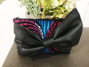 Fabric clutch bag, pink, blue, black background with PU bow