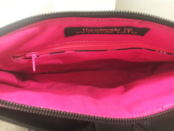 Inside of clutch, internal zip, bright pink lining.